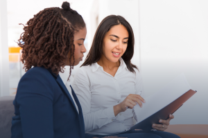 Two professional women reviewing documents together in an office setting - Headley Legal Support Services Florida